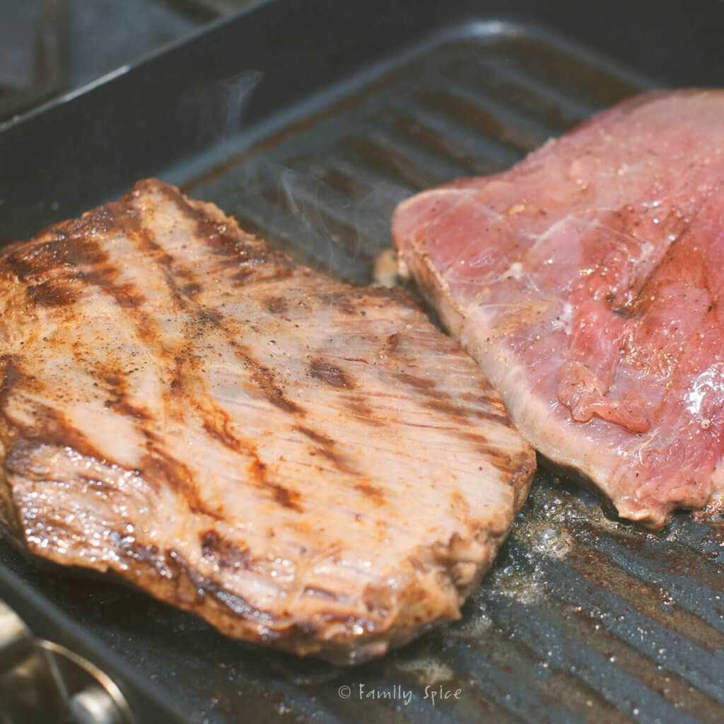 Cooking two flank steaks on a grill pan