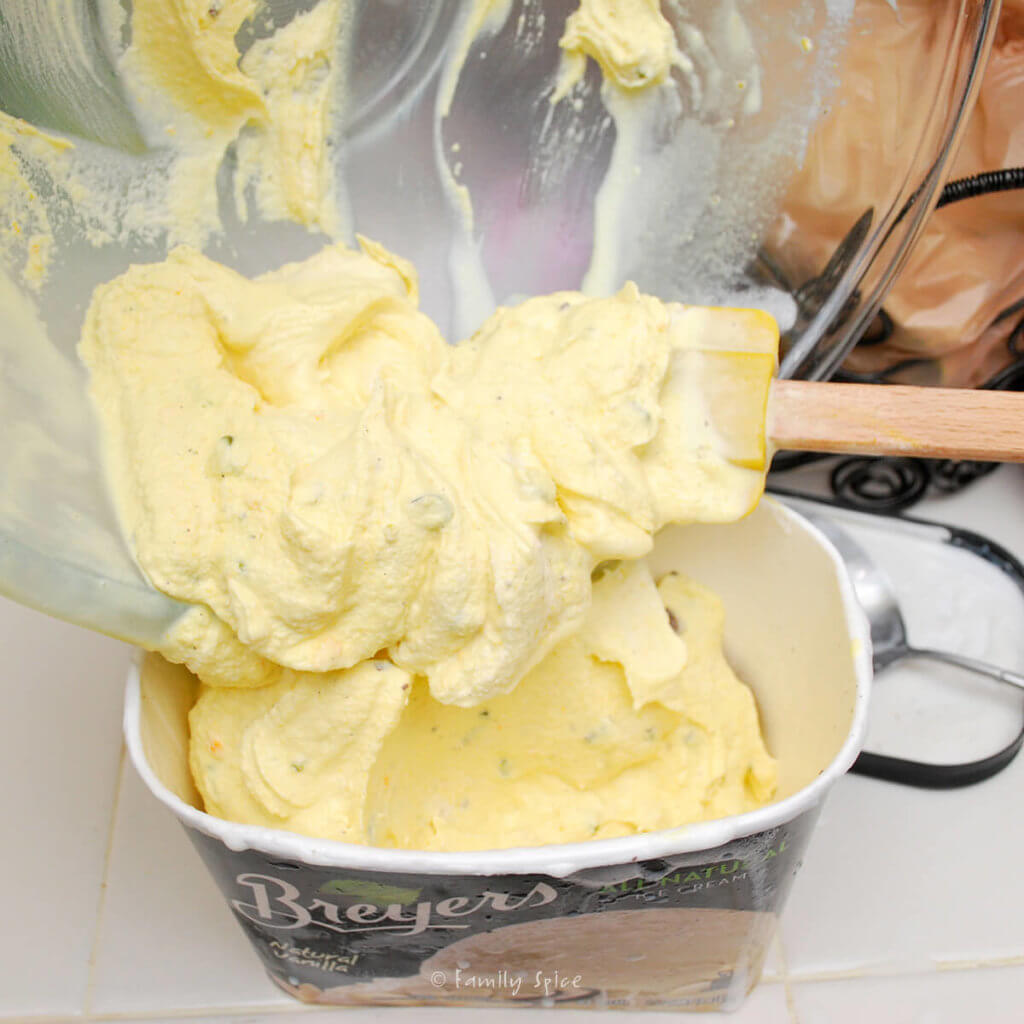 Saffron yellow Persian ice cream being transferred into an ice cream carton