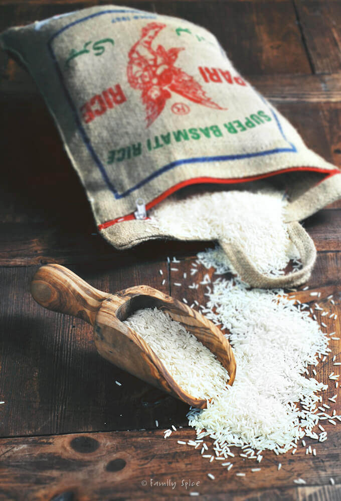 A burlap bag of long grain basmati rice spilling out of it by FamilySpice.com