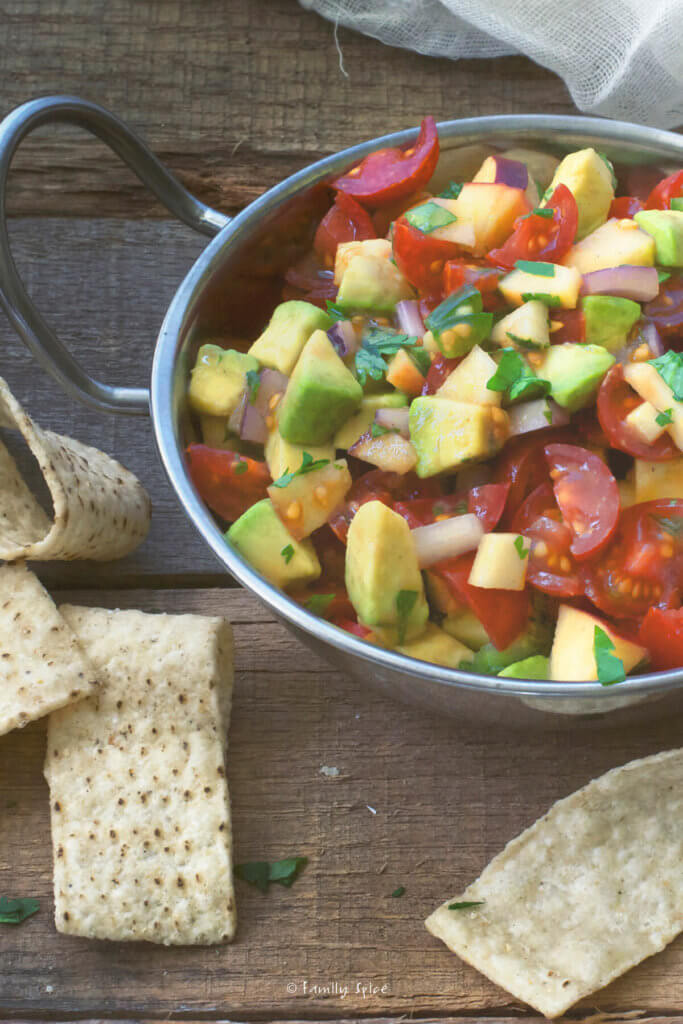 Closeup of a stainless bowl with avocado apple salsa