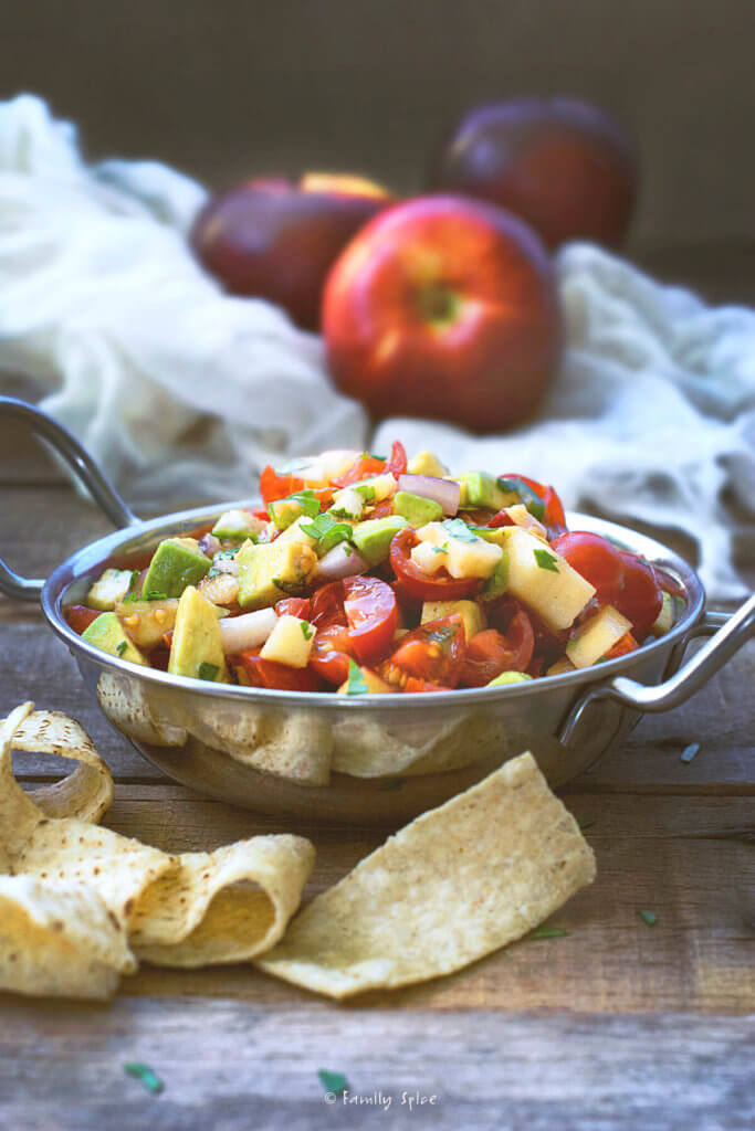 A stainless bowl with avocado apple salsa