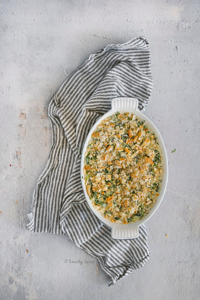 Creamed spinach greens mixture in a casserole dish topped with crushed crackers
