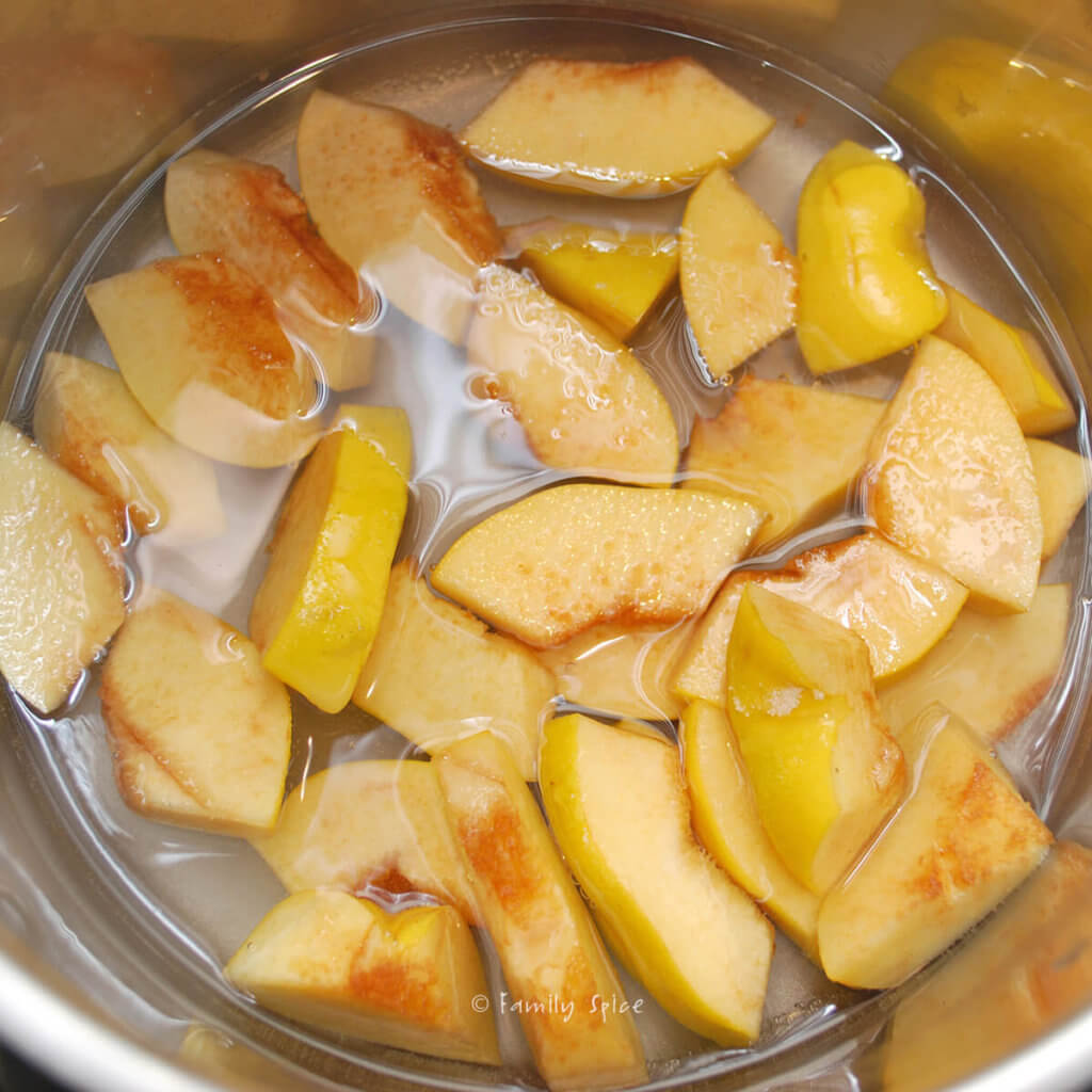 Cooking quince slices in a pot to make jam
