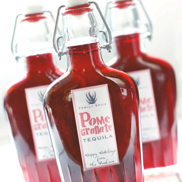 3 glass flasks filled with homemade pomegranate tequila