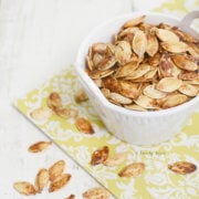 Closeup of a white bowl with lemon roasted pumpkin seeds in it