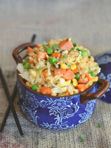 Closeup of fried brown rice with carrots, corn, peas and sausage
