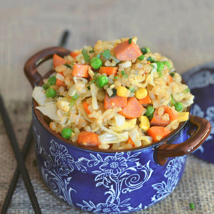 Closeup of fried brown rice with carrots, corn, peas and sausage