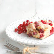 Red currant scone on a white plate with small fork next to it