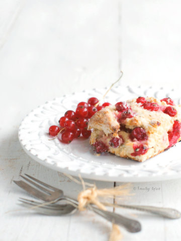 Red currant scone on a white plate with small fork next to it