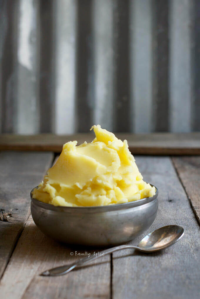Side view of a bowl of Saffron Mashed Potatoes in a metal bowl by FamilySpice.com