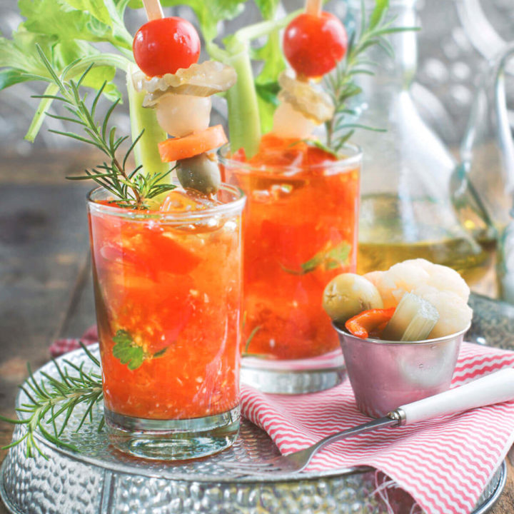 Two glasses of cherry tomato bloody marys with pickled garnishings