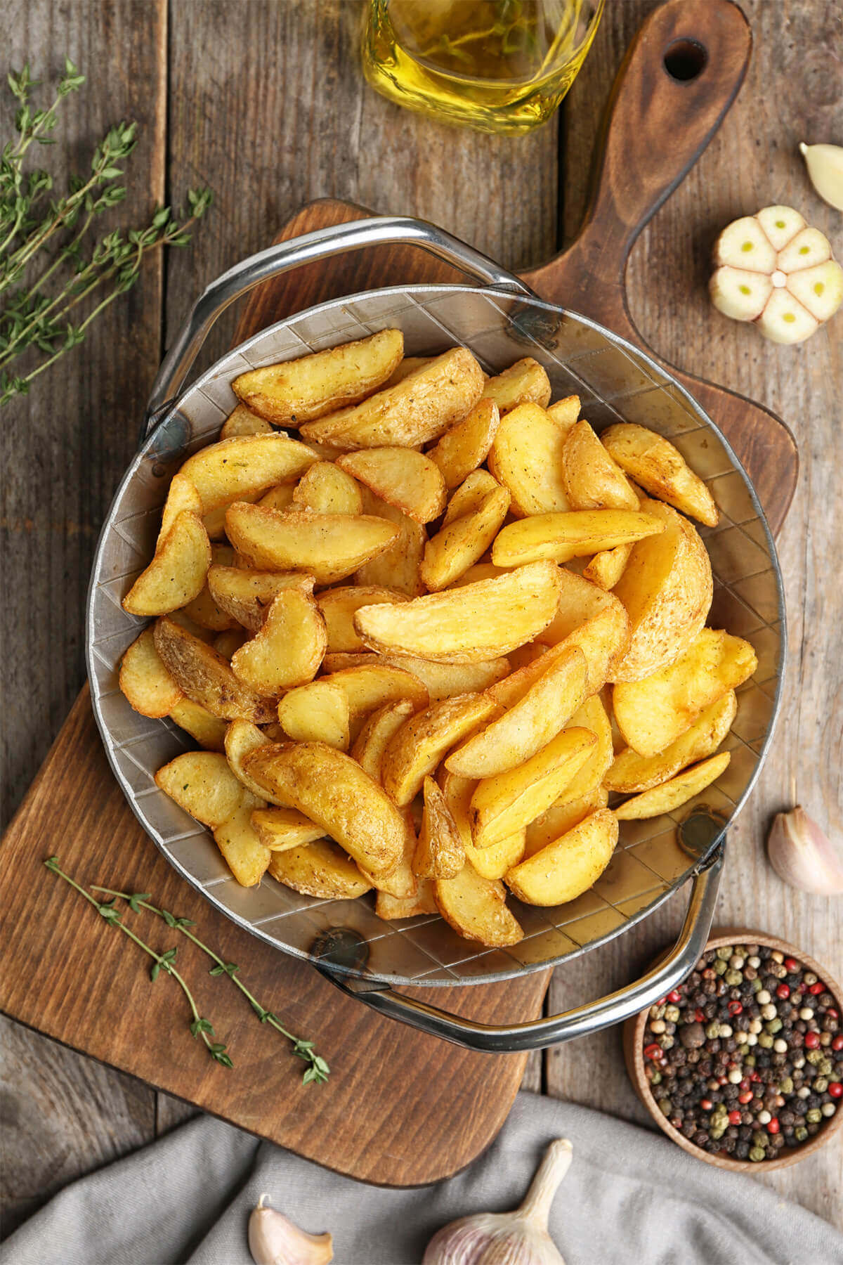 Top view of a round metal tray piled with fried potato wedges
