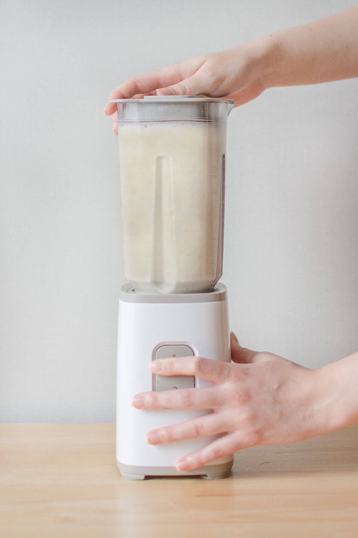 Two hands with a blender making an apple smoothie