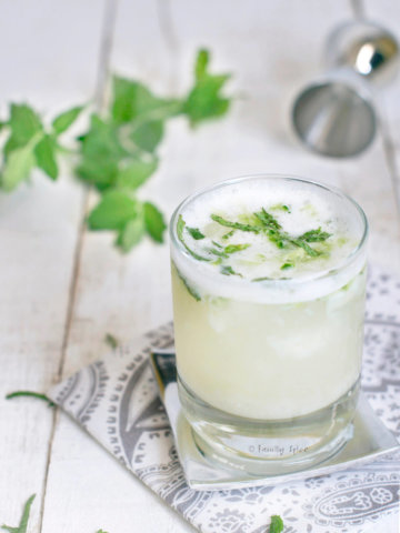 Side view of a vodka fizz garnished with fresh mint