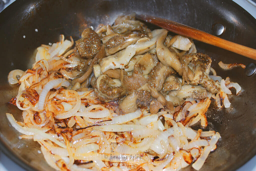 Caramelized onions in a skillet with cooked eggplant