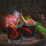 Two glasses of pomegranate mulled wine on a copper tray by FamilySpice.com