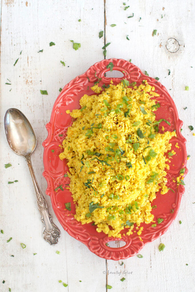 A red oval platter with turmeric cauliflower rice
