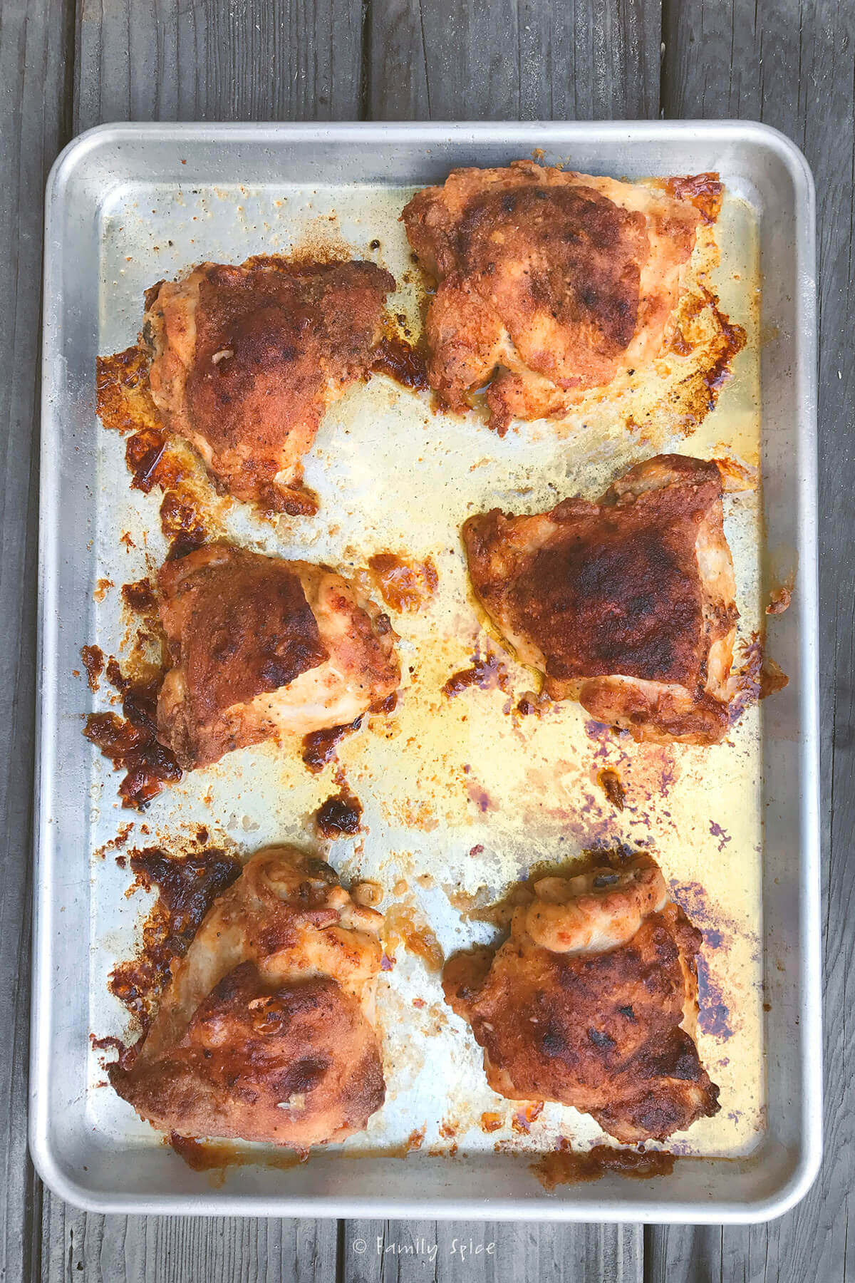 Overhead view of a baking sheet with oven fried chicken thighs