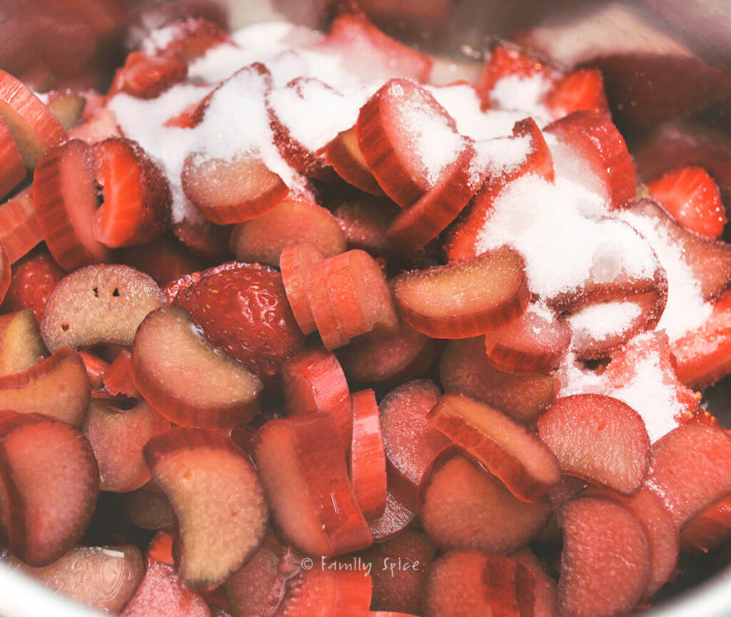 Strawberry and rhubarb in a pot with sugar on top of it
