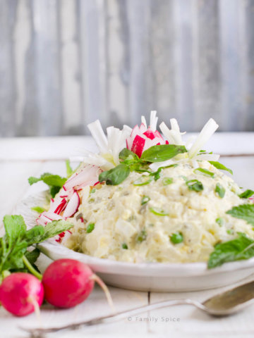 Salad Olivieh (Persian Potato Salad with Chicken) garnished with radishes and herbs