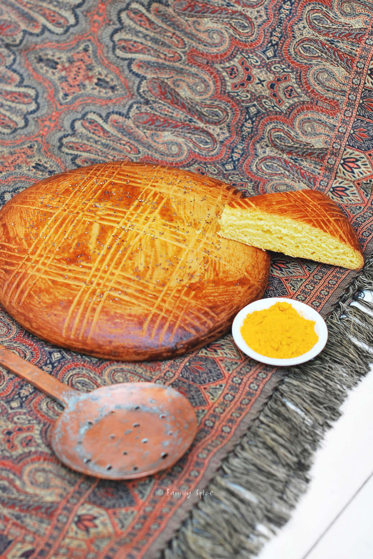 Freshly baked shirin chorek (sweet Persian bread) with a wedge slice next to it