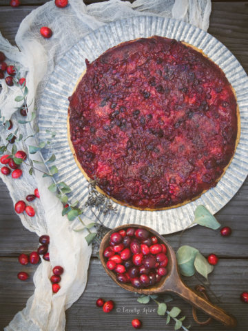overhead view of cranberry upside down cake surrounded by fresh cranberries and eucalyptus branches