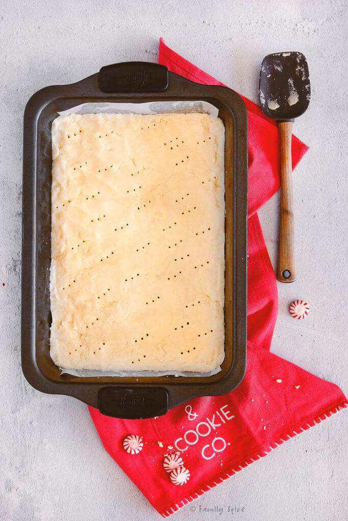 Shortbread cookie batter spread out evenly in a 9x13 metal pan