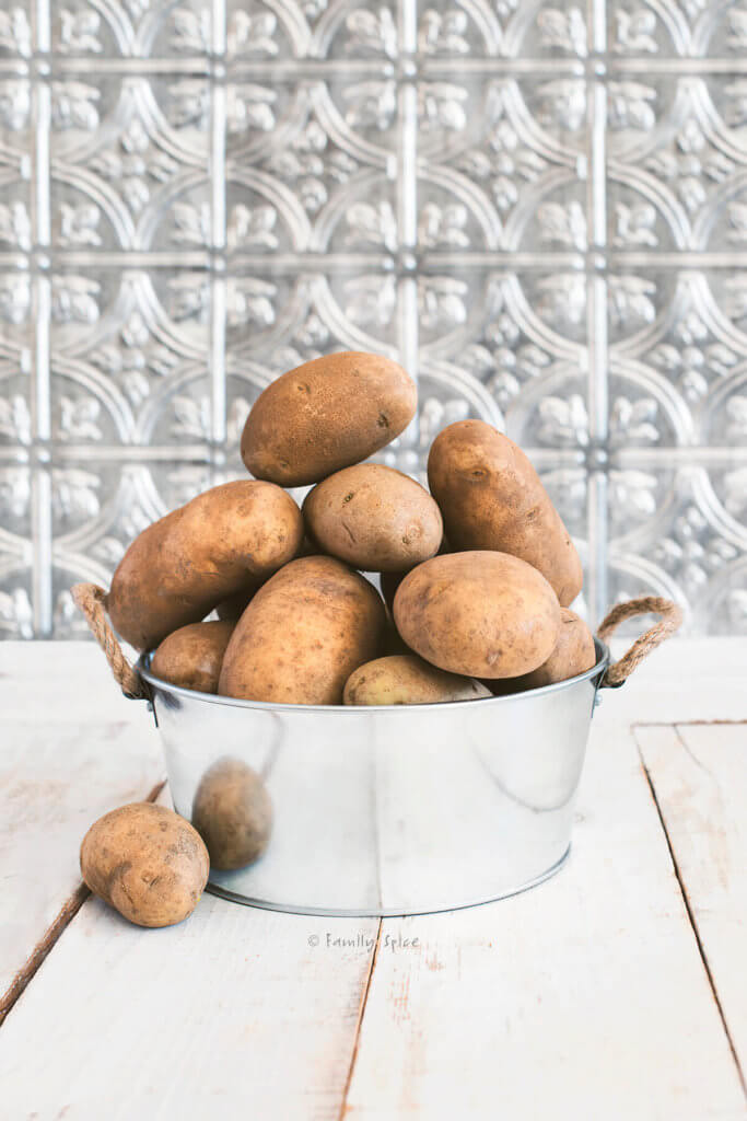 A small metal tub filled with russet potatoes
