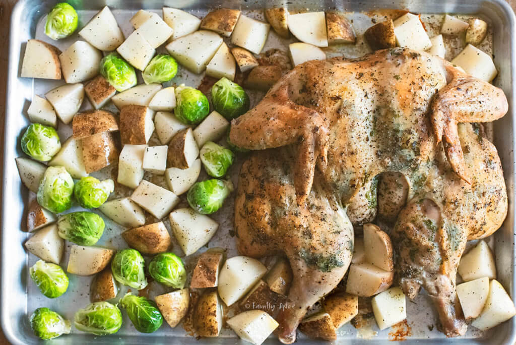 A sheet pan partially roasted with potatoes and Brussels sprouts