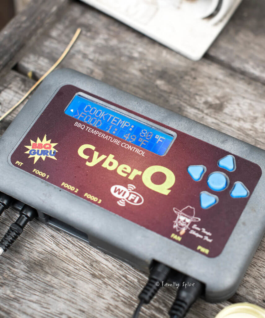 A CyberQ grill master next to a grill