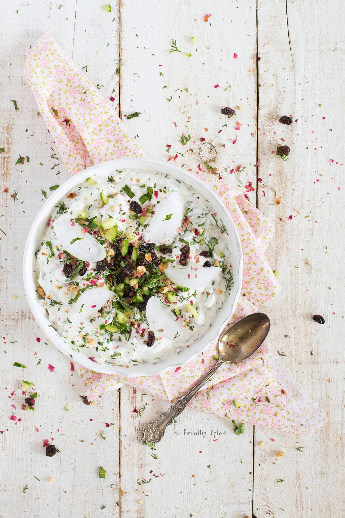 Top view of a bowl of Persian yogurt soup (ab doogh khiar) with ice on top of it