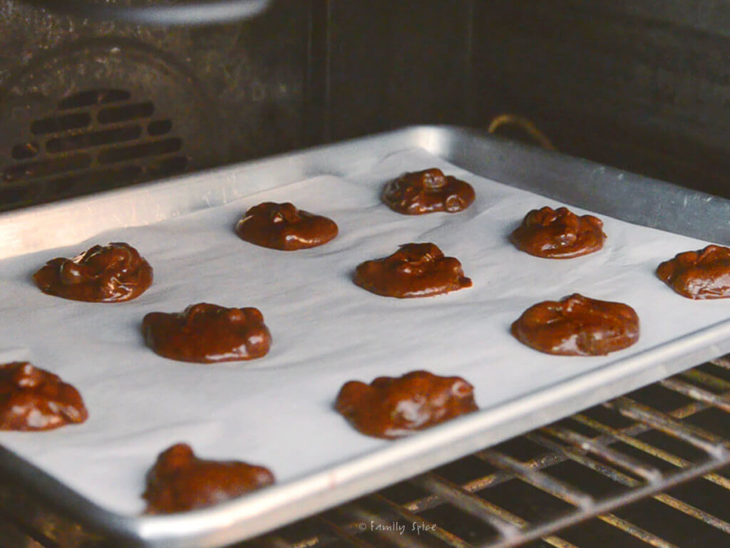Brownie cookie batter on a baking sheet lined with parchment paper ready to be baked in the oven