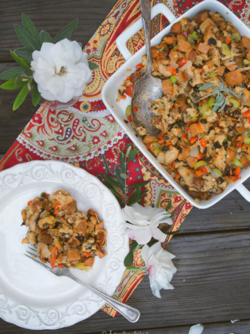 Overhead view of serving dish with cajun stuffing and a plate with stuffing on it