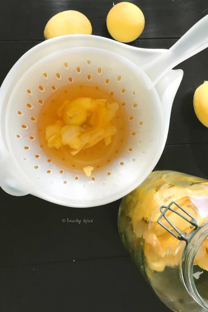 A strainer with lemon peels strained out of it