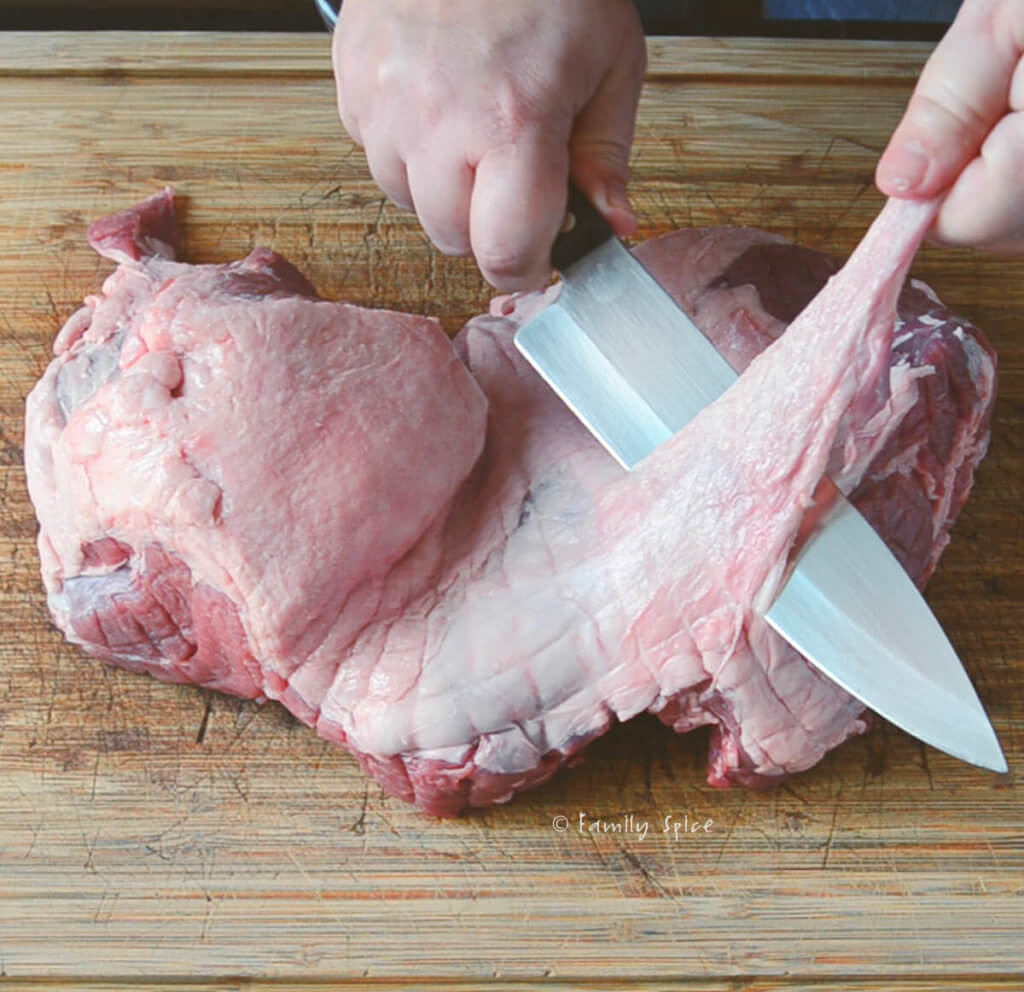 Removing large fat deposits on a boneless leg of lamb