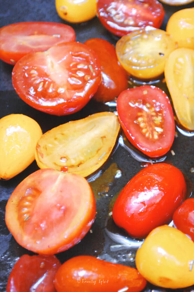 Halved cherry tomatoes on a baking sheet ready for roasting