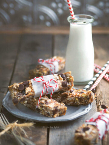 Oatmeal date nut bars wrapped in a strip of parchment paper and tied with bakers twine with a glass bottle of milk next to it