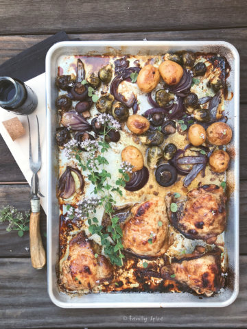 A sheet pan of balsamic chicken roasted with onions and potatoes and brussels sprouts