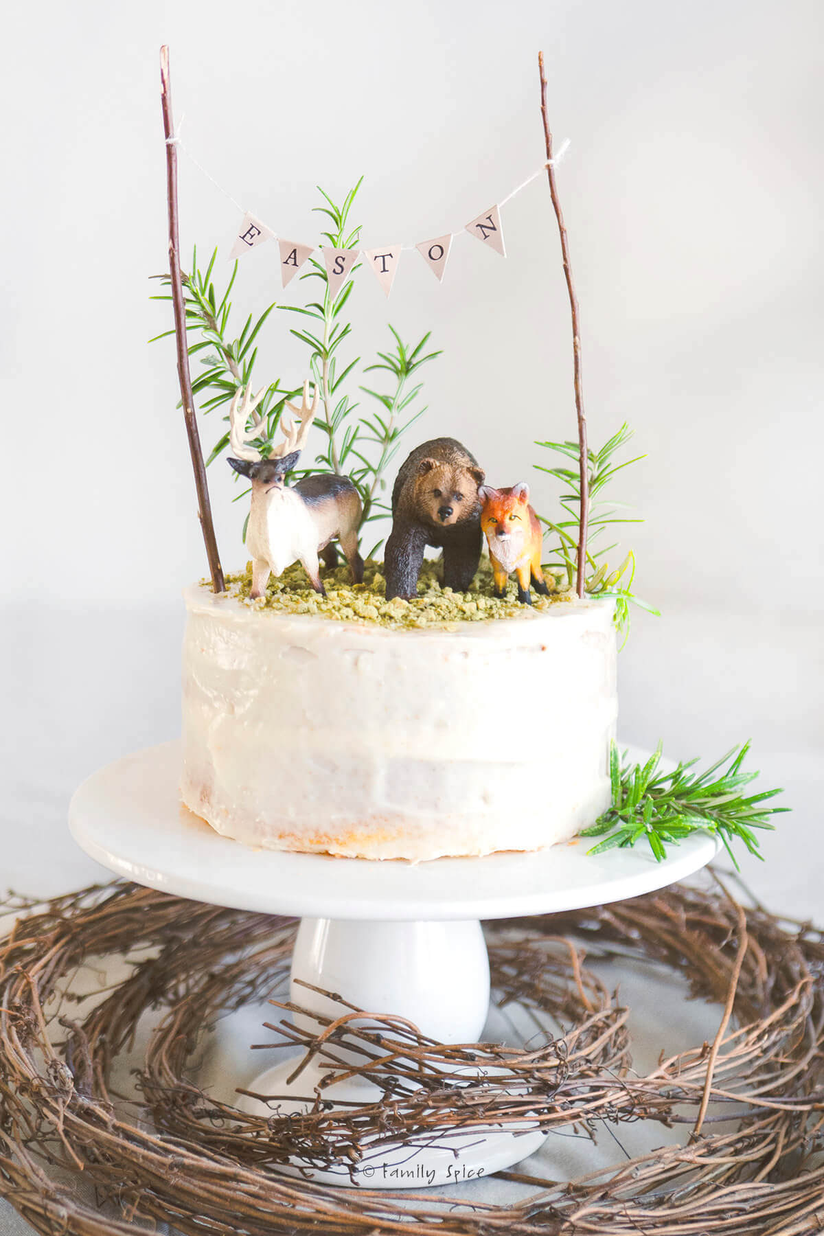 A woodlands cake decorated and on a white pedestal