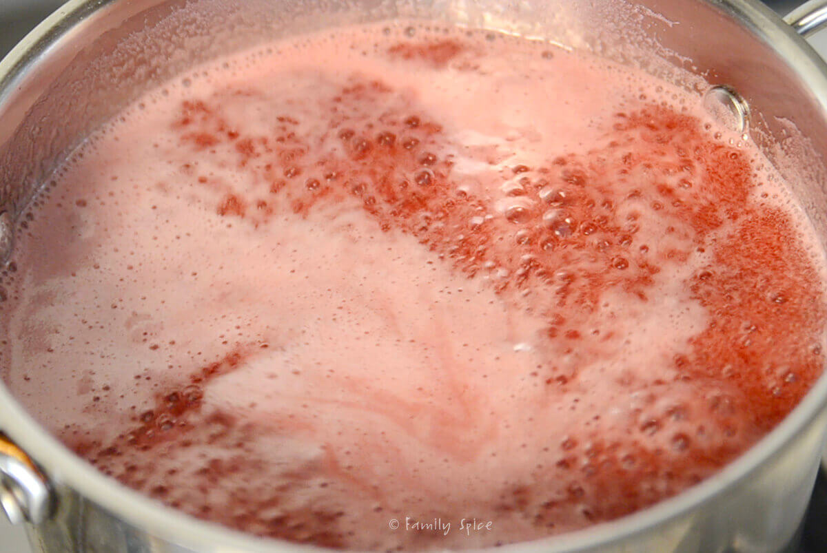 Pomegranate juice mixture boiling in a stainless steel pot