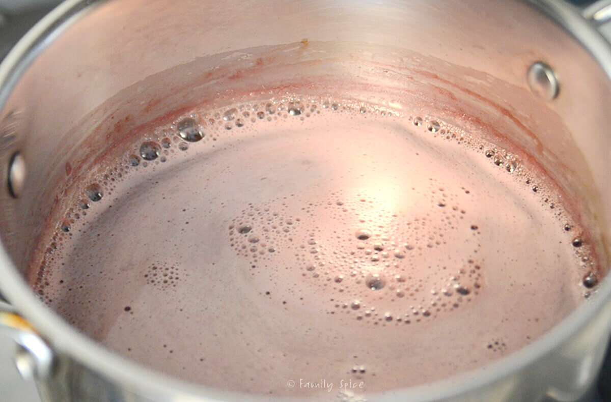 Pomegranate juice simmering in a stainless steel pot