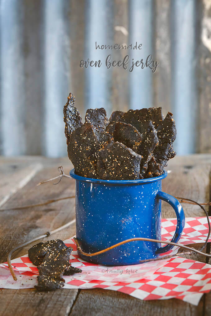 A blue cup filled with the best homemade oven beef jerky by FamilySpice.com