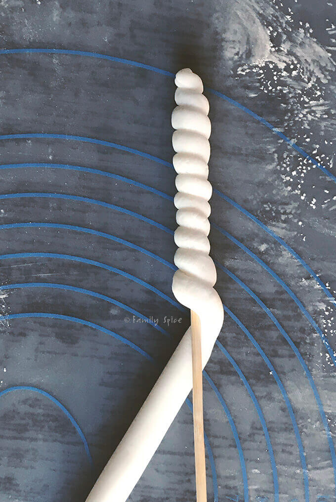 Wrapping fondant onto a bamboo skewer to make a fondant unicorn horn by FamilySpice.com