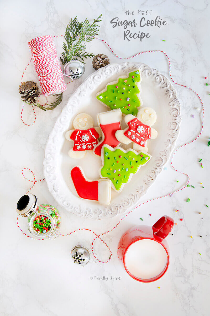 Top view of Christmas themed sugar cookies on a white plate by FamilySpice.com