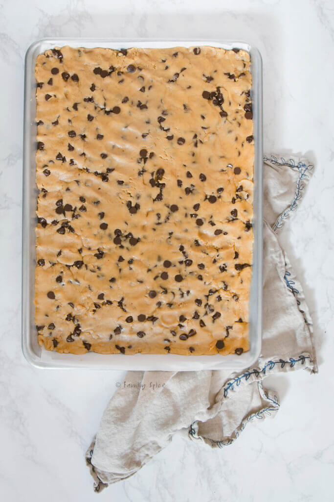 Chocolate chip cookie dough pressed into a sheet pan
