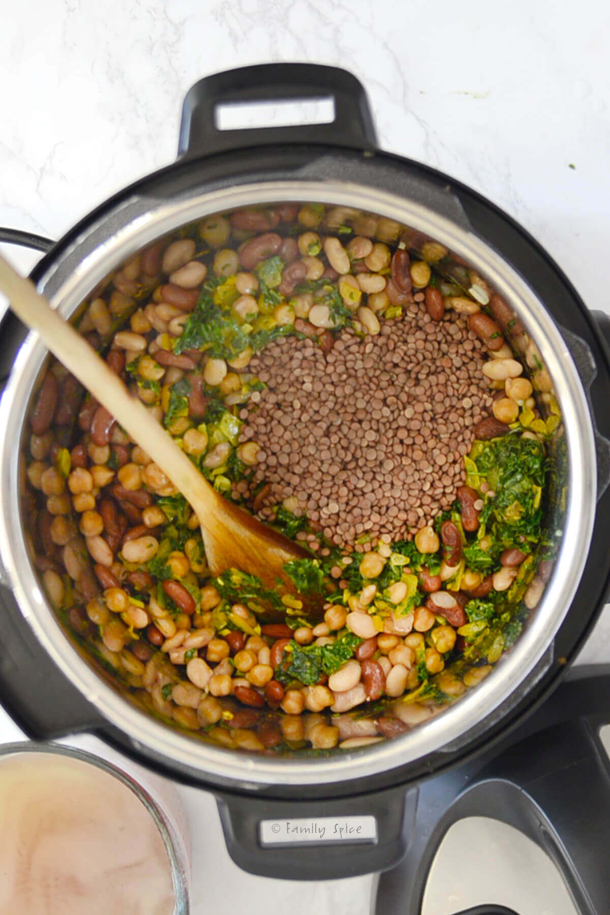 Adding dried lentils to bean mixture in the instant pot