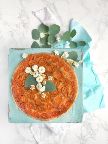 Overhead shot of kumquat upside down cake garnished with flowers