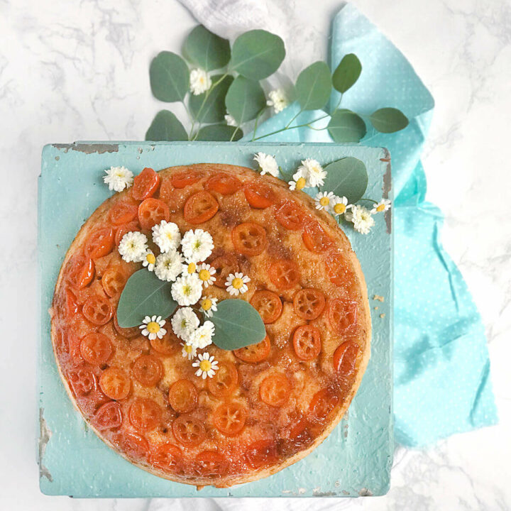 Overhead shot of kumquat upside down cake garnished with flowers