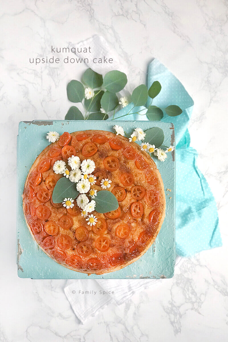 Overhead shot of kumquat upside down cake on a white marble background by FamilySpice.com