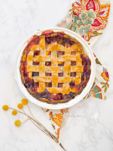 Top view of a blueberry peach pie baked and bubbly with a lattice top
